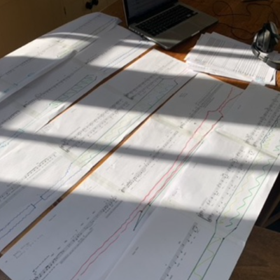 Score laid out on table in the sunshine. Day one of orchestrating the piece for full orchestra